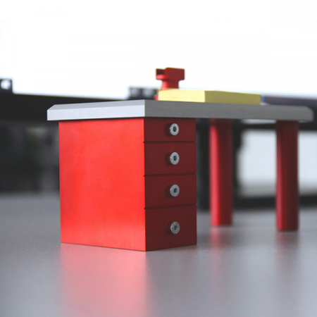 Schreibtischorganizer mit roten Tischbeinen auf Schreibtisch vor Bildschirm