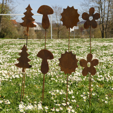 Gartenstecker im Rost-Look mit den Motiven Blume, Pilz, Sonne und Tannenbaum auf einer Wiese