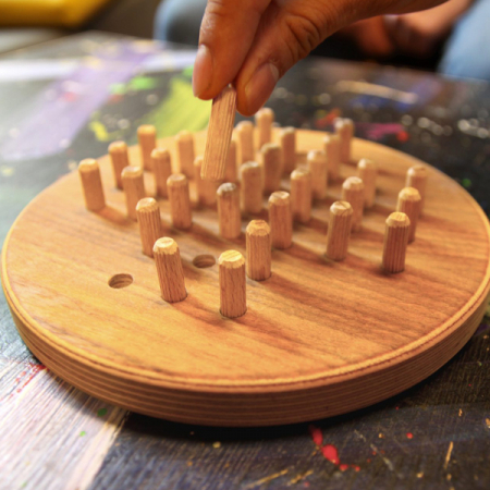 Mann spielt Holz Solitär auf einem Couchtisch